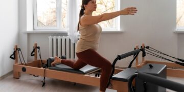 Full shot of woman taking reformer Pilates