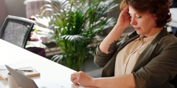 Person feeling neck and shoulder strain at a home office desk