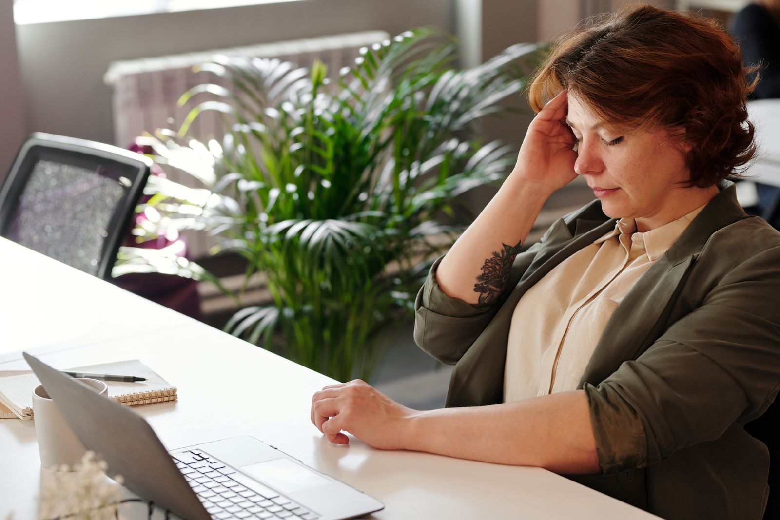 Person feeling neck and shoulder strain at a home office desk